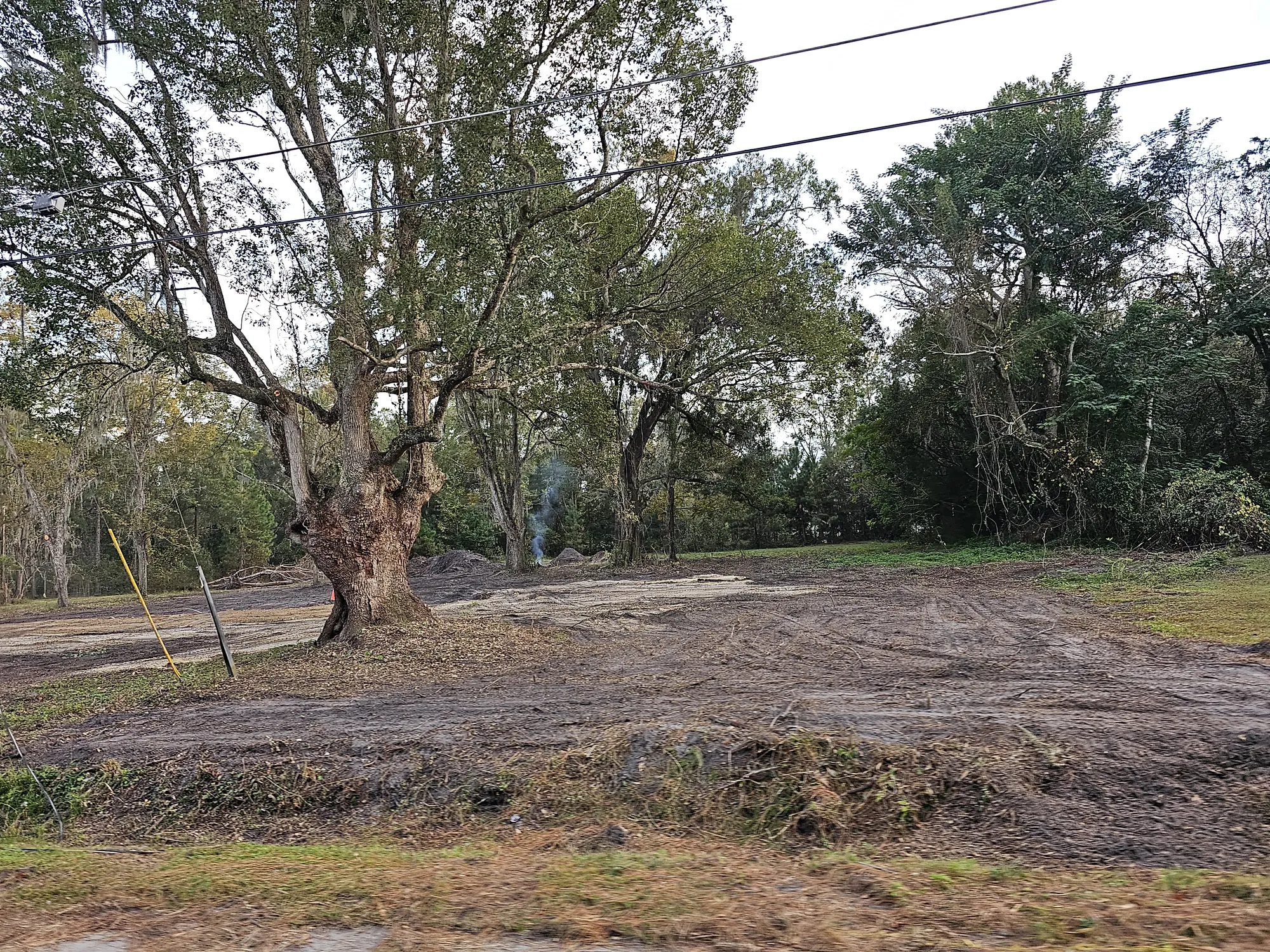 Wide view of cleared rural property with debris removed and ground prepared