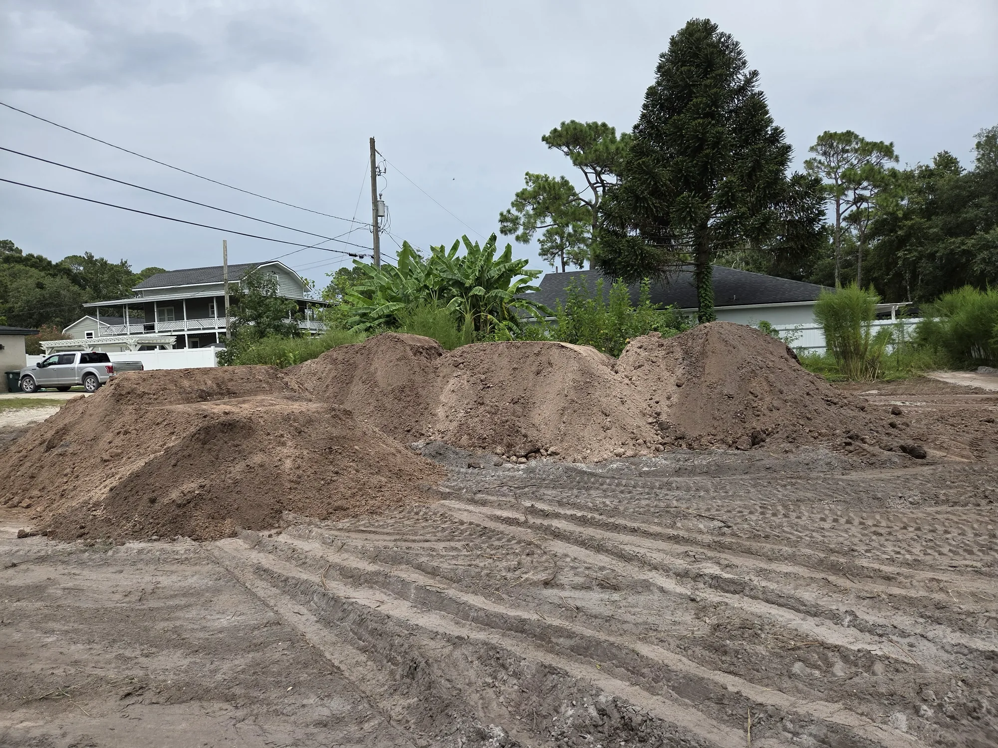 Fill dirt stockpiled on a graded residential lot during site prep in North Florida