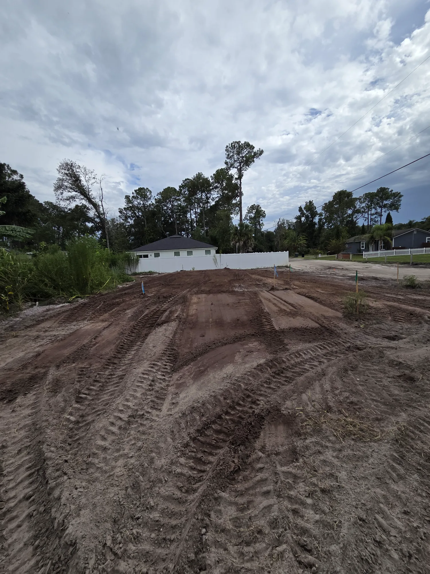Residential lot graded smooth with equipment tracks across the dirt in North Florida